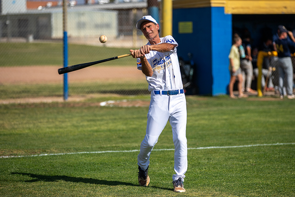 A Titan baseball player swings the bat at the ball