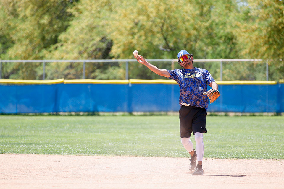A man throws a baseball during the alumni game