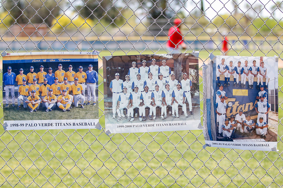 Photos of alumni baseball teams on the fence around the field
