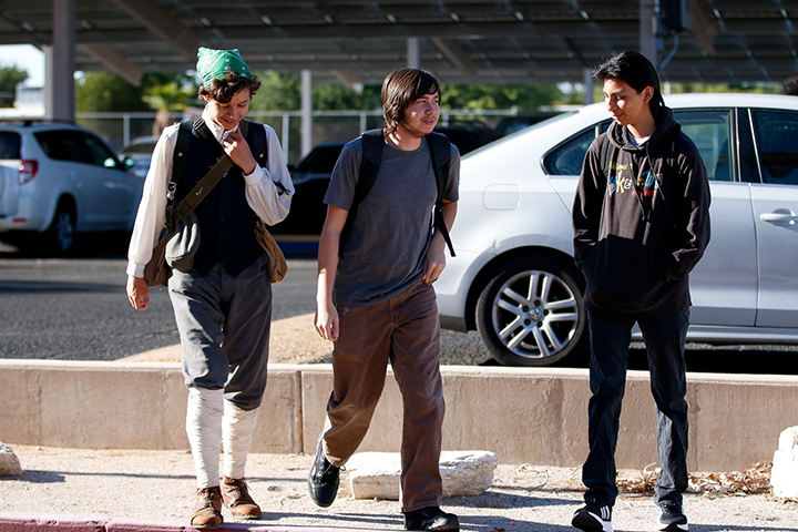 Three teen boys walk into school on the first day