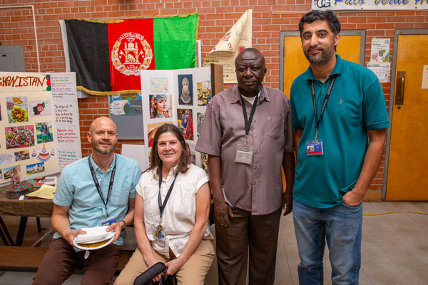Teachers take a moment to rest in front of poster displays.