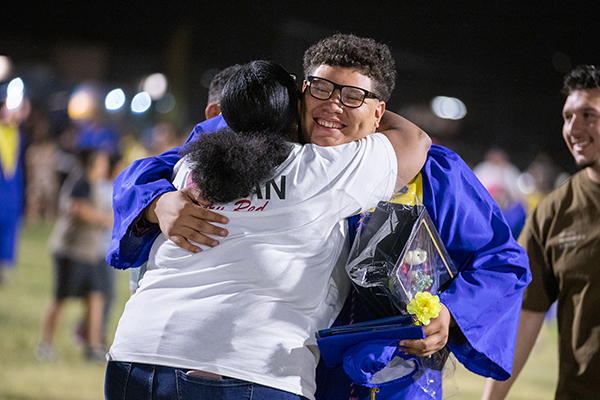 A graduate hugs his mom after the ceremony