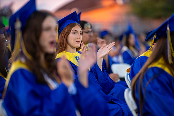 Graduates clap during the ceremony