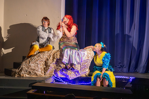 Students dressed as Ariel from The Little Mermaid and her fish friends act out a scene