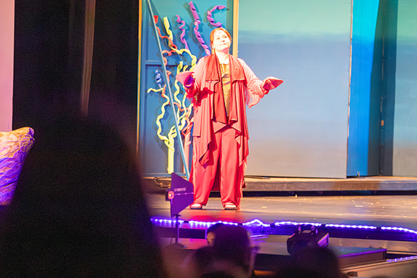 A girl dressed as Sebastian from The Little Mermaid acts out a scene