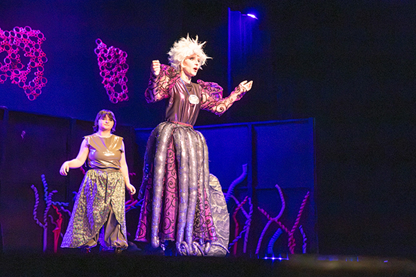 A girl dressed as Ursula from The Little Mermaid acts out a scene