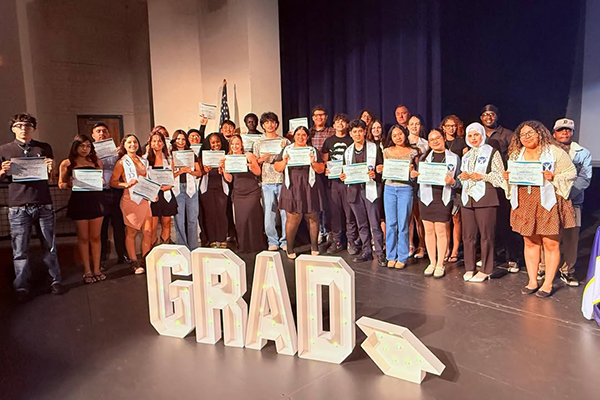 Seniors pose for a group photo with their award certificates