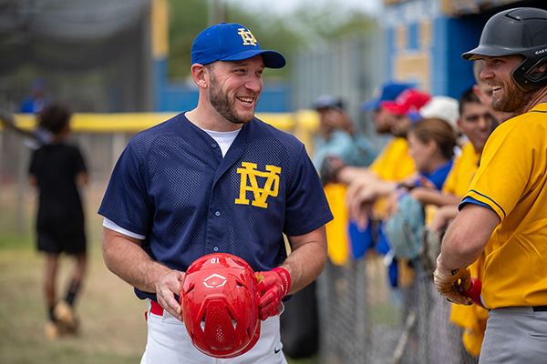 Two former Palo Verde baseball players laugh as they catch up before the alumni game